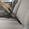 Aspirador de coche portátil en uso en el asiento