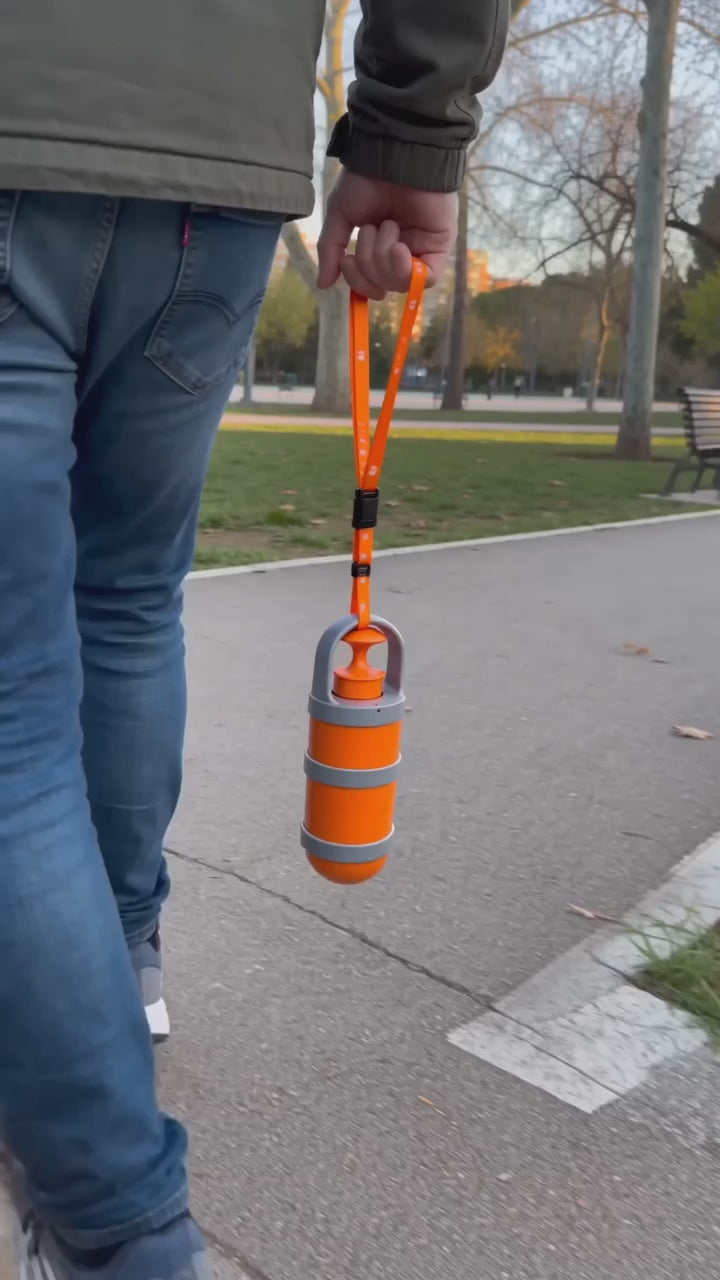Recogedor de excrementos colgado de la correa recogiendo en el parque sin tocar nada