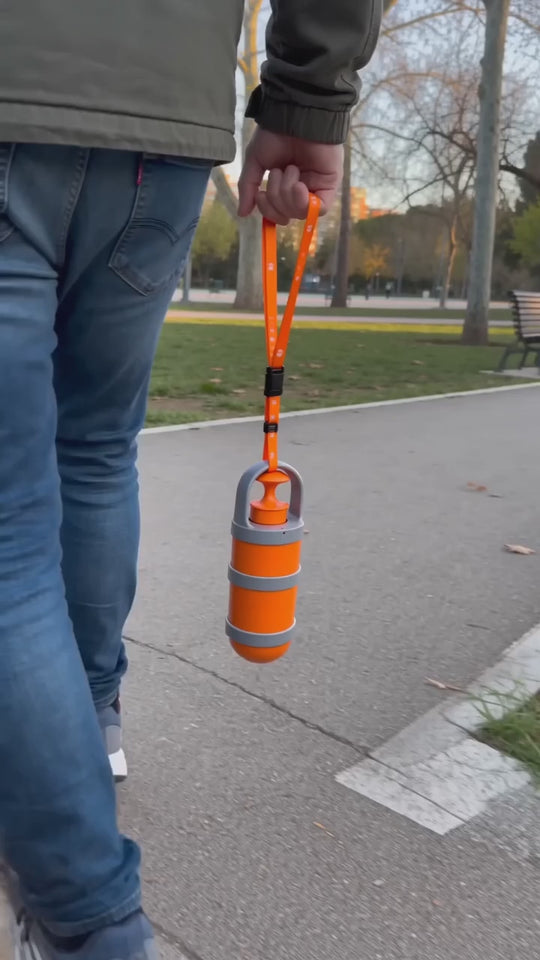 Recogedor de excrementos colgado de la correa recogiendo en el parque sin tocar nada